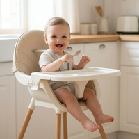 Baby sitzt lachend im SMOVO Chair Kinderhochstuhl 
mit Löffel in der Hand – authentischer Alltags-Mahlzeit-Moment